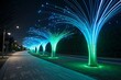 © nayem - Illuminated fiber optic trees create a magical pathway with vibrant blue and green lights at night