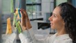 © Yuliia - Smiling happy Hispanic business woman taking sticky notes on glass in office joyful businesswoman female girl company ceo analyze result create marketing strategy stickers reminders developing startup