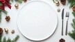 © pvl0707 - Create a festive centerpiece with an elegant table setting featuring a blank plate, cutlery, and charming Christmas decorations above a light backdrop