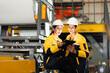 © Montri - Industrial engineers analyzing production process at factory machine line. Wearing safety uniforms and helmets. Concept of teamwork, inspection, and manufacturing operation. engineer, two worker.