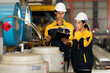 © Montri - Two engineers inspecting chemical tanks at a factory, wearing safety helmets and uniforms. Industrial safety, teamwork, and quality control in manufacturing environment. engineer, inspection, factory