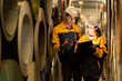 © Montri - two Industrial engineers inspecting large metal rolls in warehouse storage. Wearing safety uniforms and helmets. inventory check, manufacturing logistics, and factory teamwork. engineer, two worker.