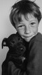 © Olly Photography - A young boy hugs a small puppy warmly, captured in a black and white photograph showcasing innocence and friendship.