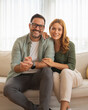 © Miljan Živković - Happy couple relaxing on sofa at home