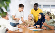 © JackF - Interested motivated young guy, student of adult school, discussing study topics with international group of coursemates of different ages gathered at table..