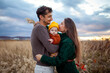 © maryviolet - Young family couple holding baby girl walking on fall meadow. Stylish mom, dad and daughter wearing warm fall clothes.