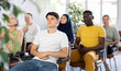© JackF - Focused young guy participating study session, sitting in auditorium with group of women and men on different ages and nationalities, listening to lecturer with interest..