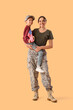 © Pixel-Shot - Little boy with USA flag and his military mother on beige background. Veterans Day celebration
