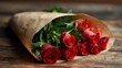 © Khalid - Romantic bouquet of vibrant red roses wrapped in brown paper lying on rustic wooden table for valentine’s day love and celebration