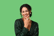 © Pixel-Shot - Beautiful young African-American woman in stylish jewelry on green background. Christmas celebration