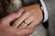 © Bipul - A man gently places a diamond ring on a woman hand, symbolizing love and commitment.