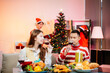 © laddawan - Enjoy the holiday spirit with a joyful Christmas celebration featuring friends, festive food, Santa hats,