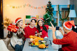 © laddawan - Enjoy the holiday spirit with a joyful Christmas celebration featuring friends, festive food, Santa hats,
