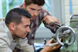 © auremar - mentor and young manual worker in industry