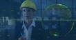 © vectorfusionart - Inspecting hologram globe, engineer wearing suit and yellow helmet in warehouse, with data overlays