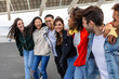© Xavier Lorenzo - Multiracial group of young friends walking together outdoors. International youth community concept with diverse teenage people having fun hugging each other in city street