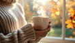 © Triyana - Cozy autumn vibes with steaming coffee in hand, sweater weather feels, a moment of peaceful relaxation by the window with fall leaves