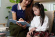 © itchaznong - Nurturing Education: Mother and Daughter Engaged in Learning