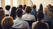 © Vasiliy - Rear view of an audience at a business conference or seminar. Group of people listening to a speaker during a presentation. Professional training and corporate education concept
