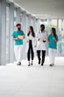 © Zoran Jesic - Medical team walking and discussing in hospital corridor