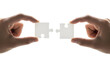 © A-STOCK - The concept of two hands bringing together white puzzle pieces signifies connection, partnership, and the successful completion of a shared goal or challenge