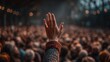 © Mariia - Crowd at a public event with a raised hand showing support during a moment of engagement in an indoor setting