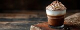 Layered Coffee Drink with Whipped Cream and Cocoa in a Glass on a Wooden Table