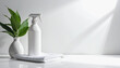 © PHAISITSAWAN - White disinfectant spray bottle and soft white towel on bright white table for effective home cleaning and hygiene practices