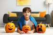 © New Africa - Halloween celebration. Boy with different pumpkins on floor at home
