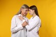 © New Africa - Mother and daughter hugging on orange background