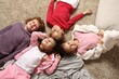 © New Africa - Cute children in pajamas lying on floor at home, above view