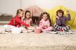 © New Africa - Cute children in pajamas eating popcorn on floor at home