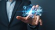 © qawi - Professional businessman interacting with holographic CRM interface for enhanced customer relationships and business growth insights