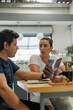 © Gener Vázquez - Couple Discussing Content on a Smartphone in a Cafe