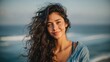 © Johannes - portrait of young woman at sea looking at camera smiling latin hispanic girl standing at the beach with copy space and looking at camera happy mixed race girl in casual outfit with wind in her hair n