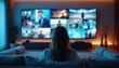 © Vadym - Woman sitting on sofa in modern living room watching video wall with variety of multimedia content including news movies sports. Looks relaxed in front of large screen with multiple screens. Room