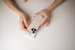 © dikushin - Top view of female hands unpacking new mobile phone from elegant box on white table, capturing thrill of receiving modern gadget and anticipation of exploring features, close-up.