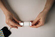 © dikushin - Top view of female hands connecting mobile phone cable to white adapter while sitting at table, illustrating process of data transfer and charging in modern workspace. Concept of modern technology.