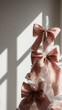 © Yuliya Kashirina - A close-up of a decorative tree adorned with large, soft pink bows. The bows are made of textured fabric, creating a festive and colorful accent. Christmas background.