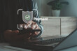 © MUNTHITA - Person using smartphone and laptop, showing digital protection, fintech innovation and safe data encryption for modern financial transactions and e-commerce. Secure online payment concept.
