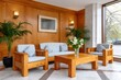 © kardaska - Hotel lobby waiting area with modern wood furniture and plants