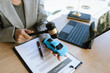 © Witoon - A lawyer signing a car contract with a gavel and a toy car on the desk, symbolizing car law, insurance, or legal agreement.