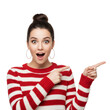 © yendisupiandi - Enthusiastic young woman in striped sweater gesturing towards copy space with surprise expression