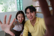© itchaznong - Young couple sharing joyful moment on video call, engaging with friends