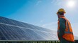 © sungedi - Technician wearing protective gear inspects large array of photovoltaic panels under bright sunlight