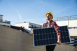 © Westend61 - Engineer wearing hardhat carrying solar panel