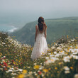 © Usaginikov - Bride in lace dress walking through wildflowers by the sea
