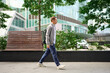 © ADDICTIVE STOCK - Man walking outdoors in urban office area