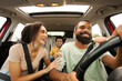 © Home-stock - Excited African American parents and son driving car, chatting and laughing, happy family of three going on vacation, windshield view