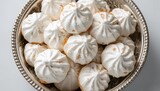 Plain white vanilla meringue cookies served in a silver bowl, fiber-dense choice
